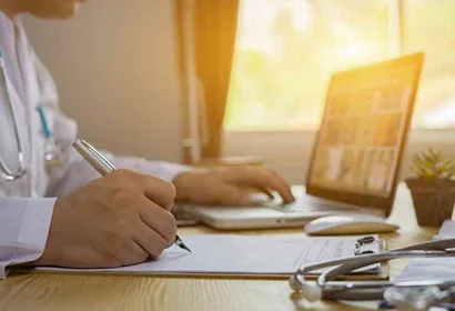 Doctor writing notes on a piece of paper.